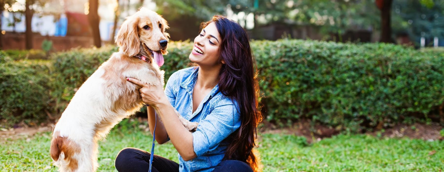 a person kneeling next to a dog