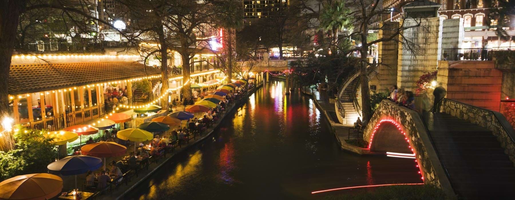 a river with umbrellas and buildings