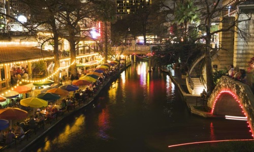 a river with umbrellas and buildings