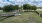 a fenced in area with trees and grass